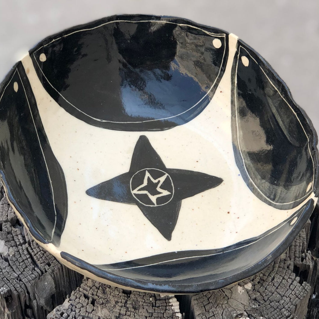 Hand-painted ceramic bowl with a native black star